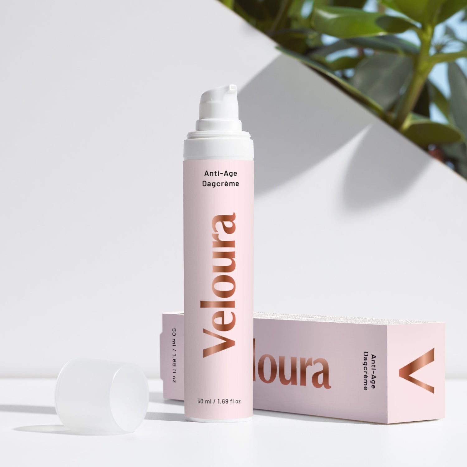 Flesje Veloura Anti-Age Dagcrème in zachte roze verpakking, geplaatst naast bijpassende doos met natuurlijke huidverzorging en planten op de achtergrond.