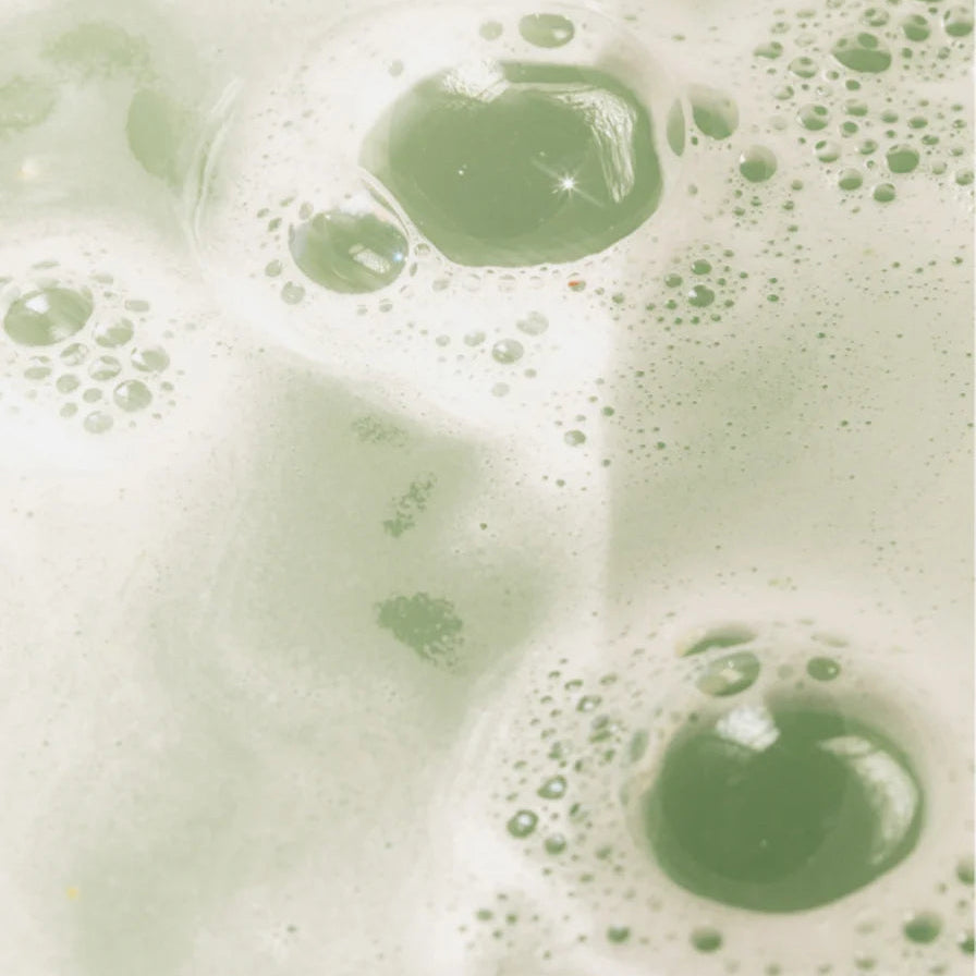 Luchtige schuimvorming met een groene tint die doet denken aan natuurlijke ingrediënten, perfect passend bij Glans Shampoo Smoky Green Vetiver voor haarverzorging.