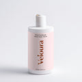 Fles Glans Conditioner Smoky Green Vetiver van Veloura met een lichte roze etiket, geschikt voor haarverzorging met natuurlijke ingrediënten voor een gezonde glans.
