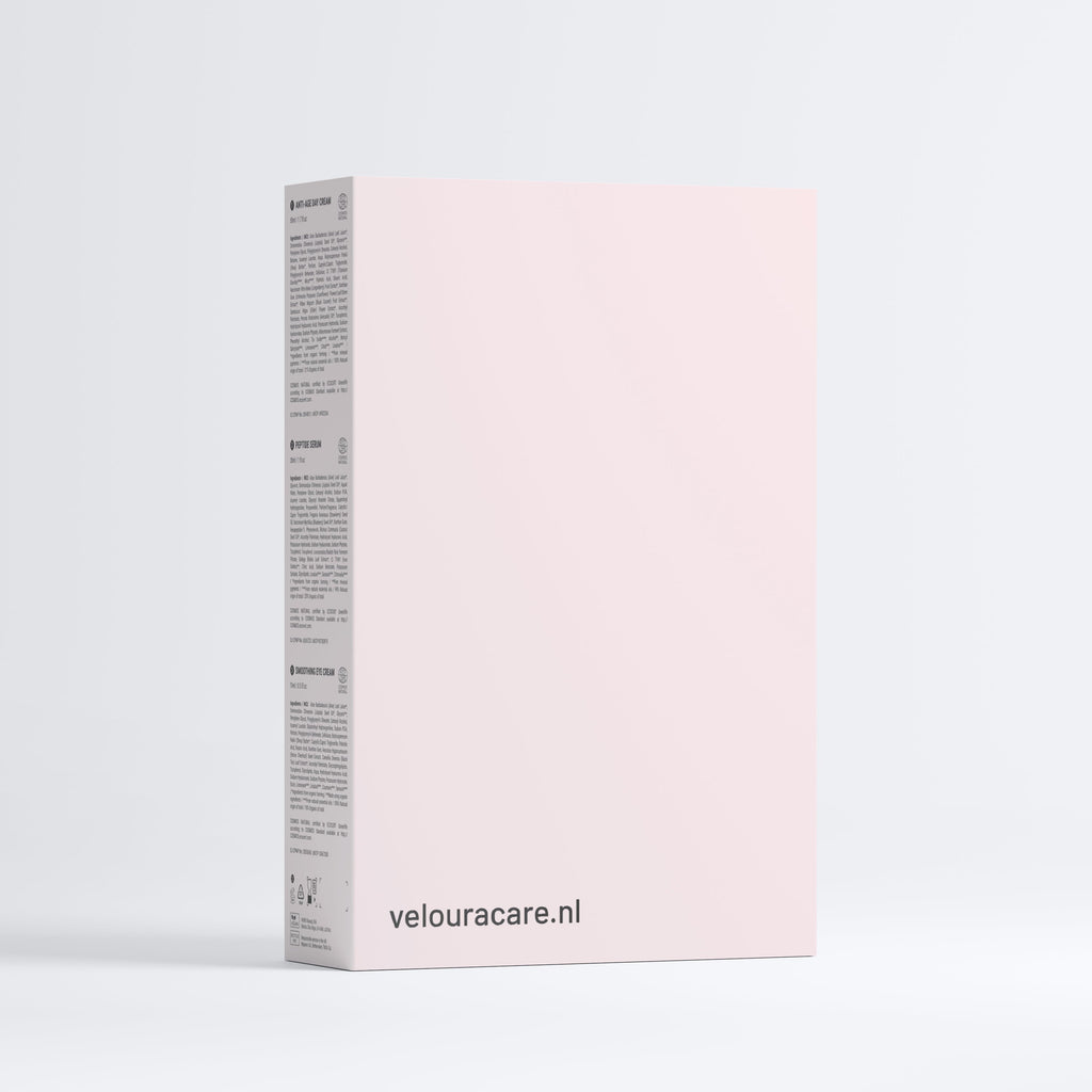 Minimalistische lichtroze verpakking van de Anti-Aging Collection Box met informatie over natuurlijke huidverzorging en Veloura branding zichtbaar op de zijkant.