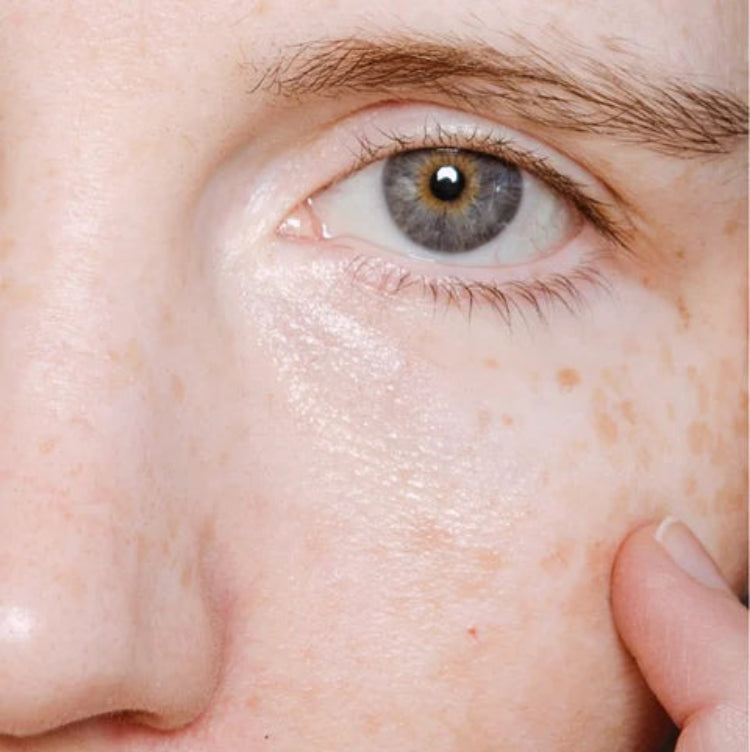Close-up van gezicht met Veloura peptide serum op de huid, zichtbaar gehydrateerde en glanzende teint met natuurlijke huidtextuur, voor anti-aging verzorging en een stralende huid.